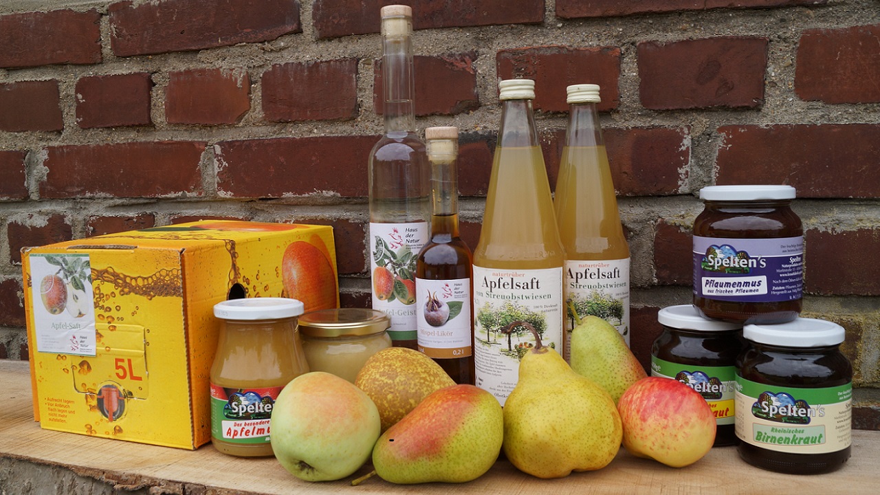 Obst und Obstprodukte auf einem Tisch: Äpfel, Birnen, Säfte, Kraut, Mus
